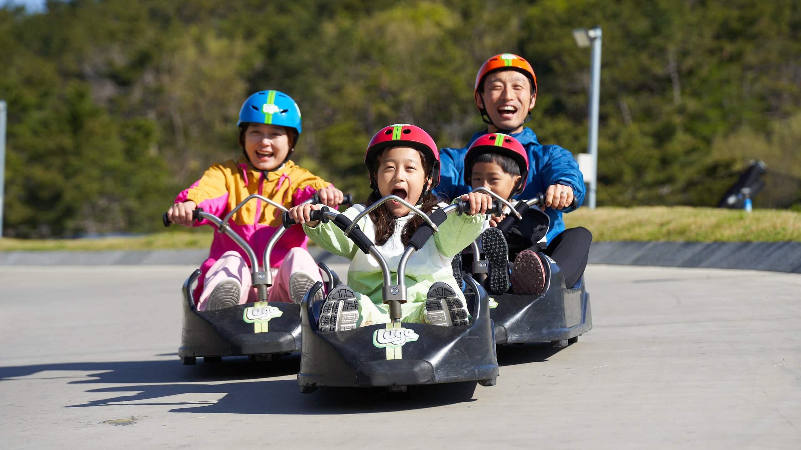 A small girl leads her family down the Busan Luge track.