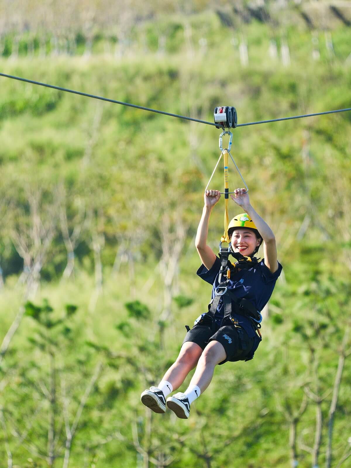 A lady smiles as she ziplines down the Skyline Luge Busan Hyfly.