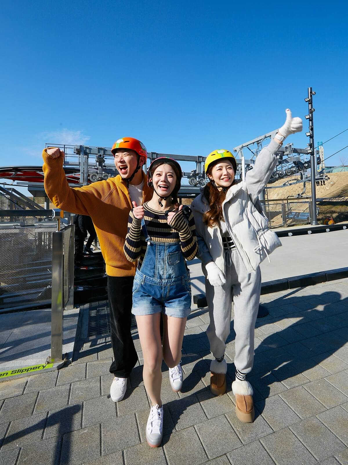 Three friends pull smile and pull 'thumbs up' as they exit their first Luge ride.