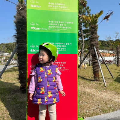 A small child checks her height to ride the Luge at Busan.