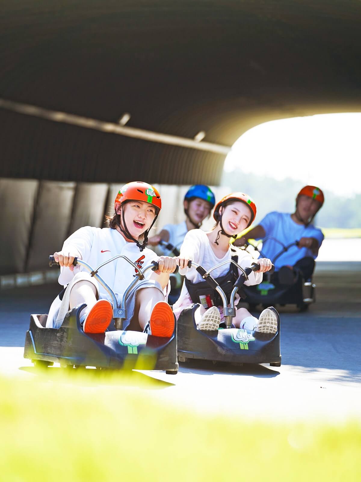 A group of people ride through a tunnel on the Busan Luge.