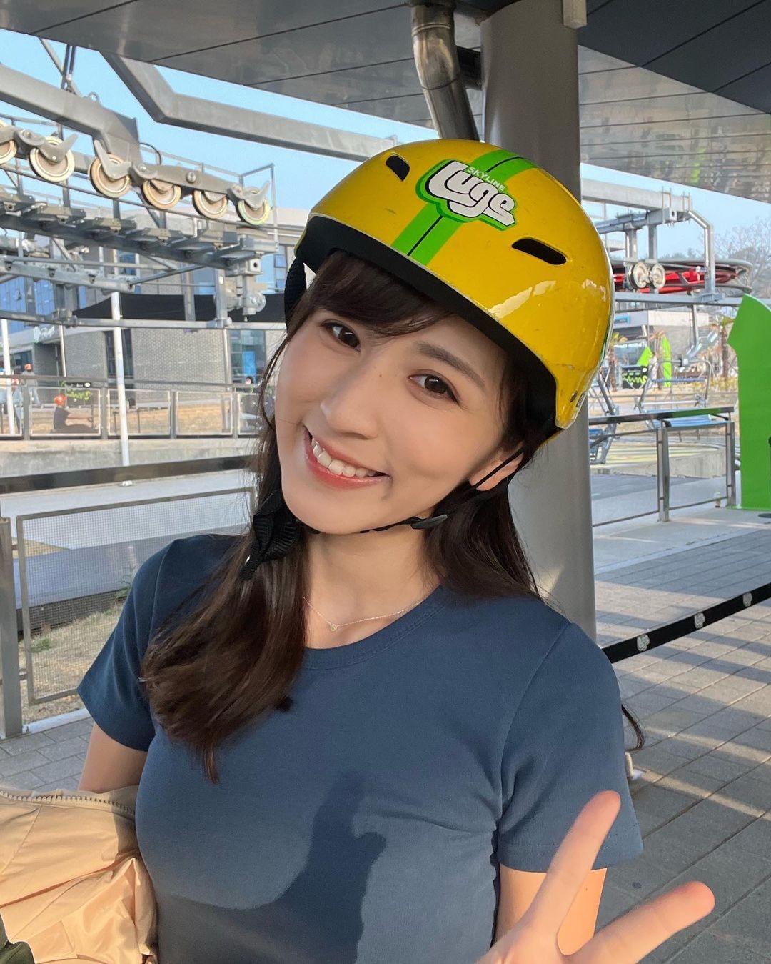 A lady poses for a photo waiting in line ready to ride the Busan Luge.