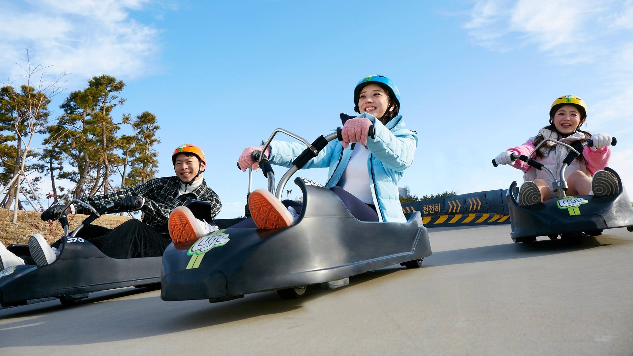 Three friends race down the Busan Luge tracks together.